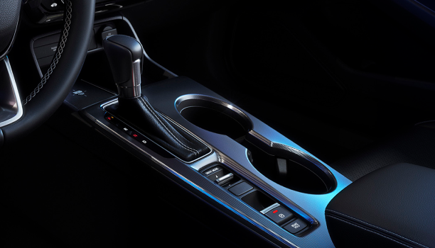 Closeup of gear shifter and cupholder console.