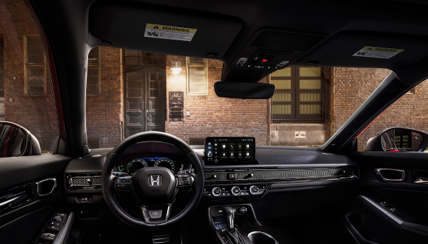 Interior panoramic view of the windshield on a Hatchback parked in front of brick wall in an old warehouse district.
