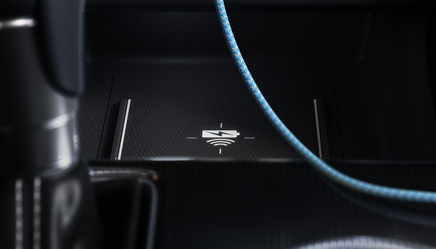Closeup of wireless charging pad in front of gear shifter.