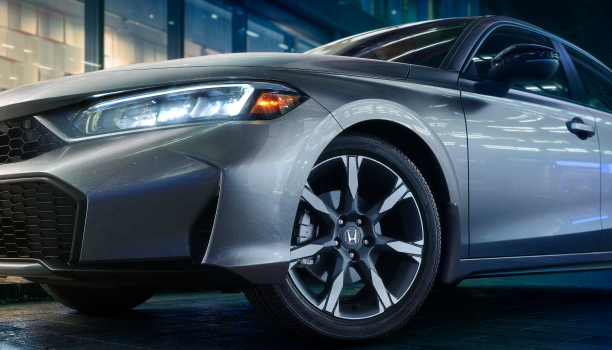 Closeup of wheel on a grey Hatchback.