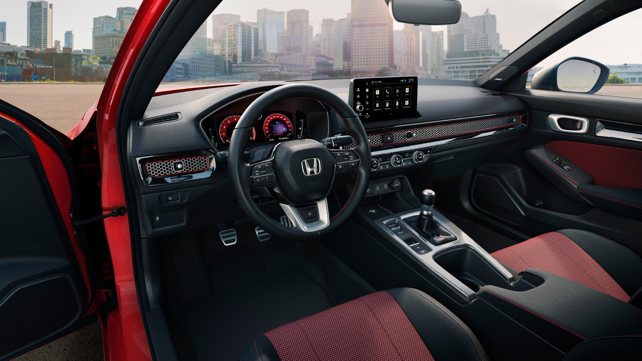 3/4 view of steering wheel and front dashboard of Civic Si, seen from the driver’s side.