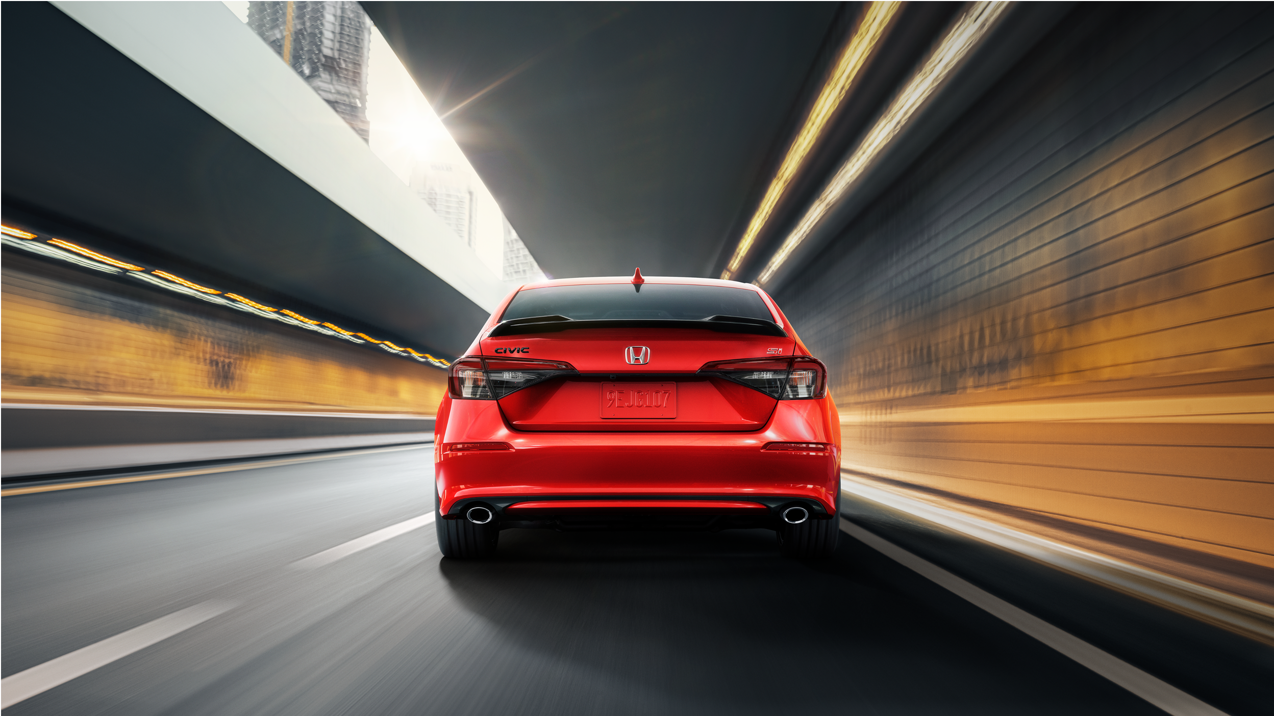 Rearview of red Civic Si driving in tunnel.