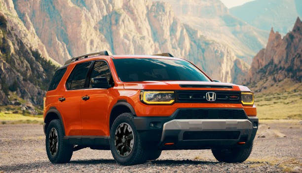 Front view of an orange Honda Passport in an outdoor space. 