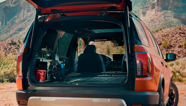 Rear-view of open tailgate on a Honda Passport parked in a desert. 