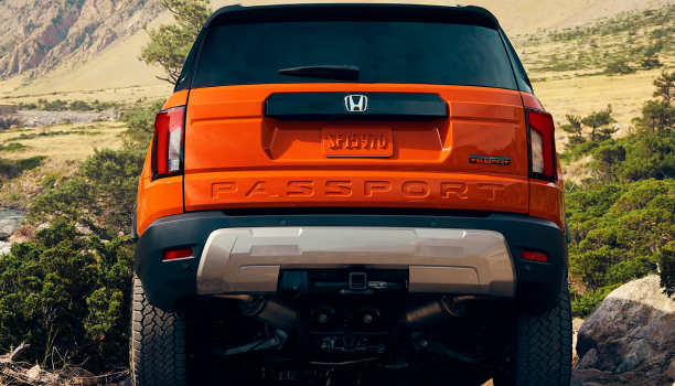 Rear-view of an Orange Honda Passport. 