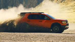 Front view of a Passport is shown driving through rugged terrain. 